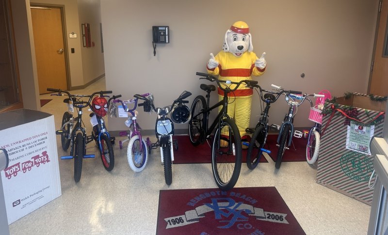Sparky shows off bicycles ready for Rehoboth Beach Volunteer Fire Company to deliver to Toys for Tots.
